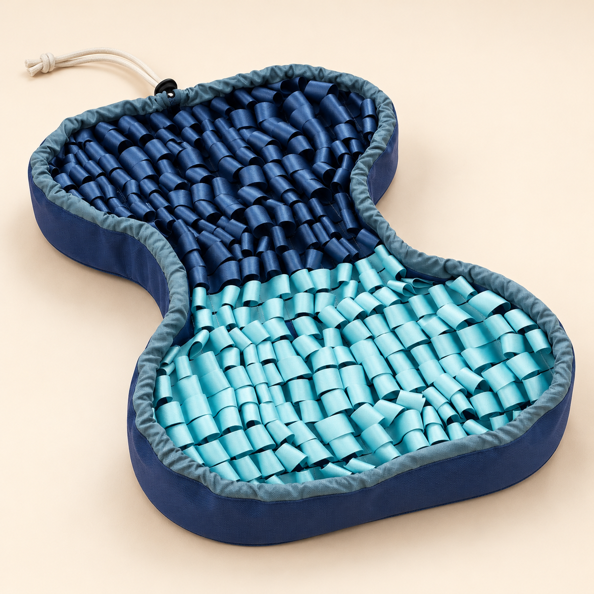 Complete PuzzlePup SmartMat showing its broad bone outline, raised cloth sides and navy-end drawcord